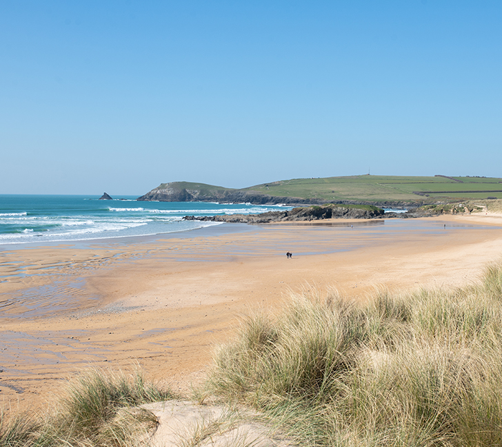 Constantine Bay beach with rolling surf, golden sands and coastal scenery
