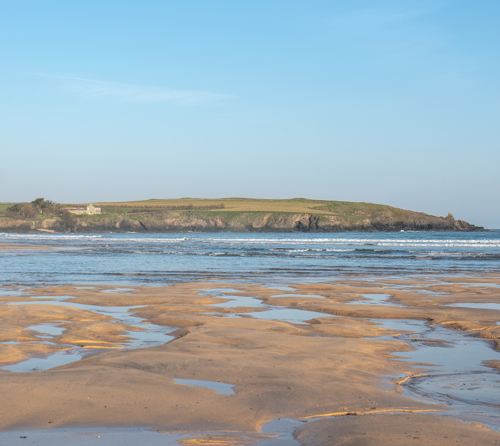 Harlyn Bay beach with gentle waves, sandy shore and coastal scenery