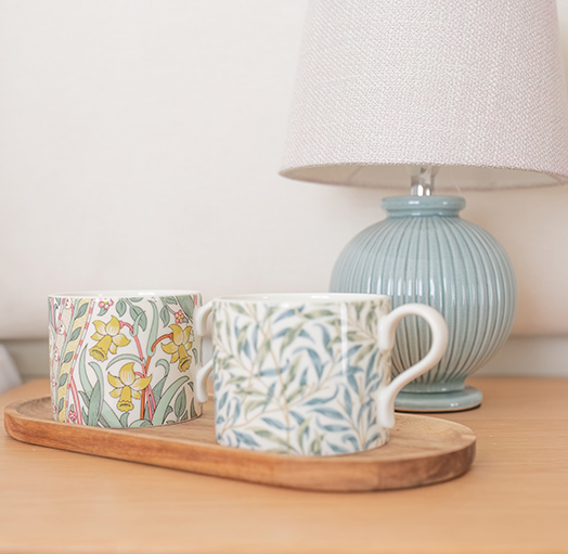 Close up of a bedside table with a contemporary lamp and decorative accessories.