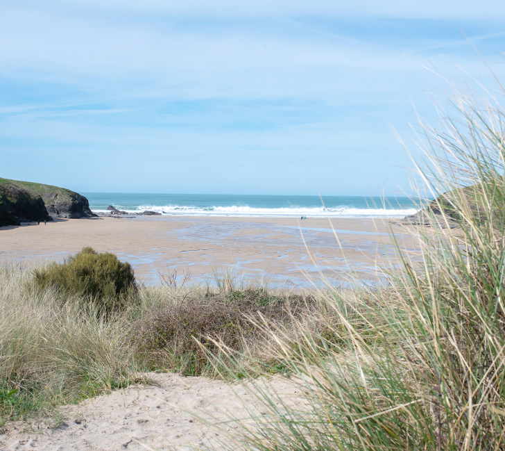 Porthgovan Bay with rugged cliffs, sandy beach and turquoise water
