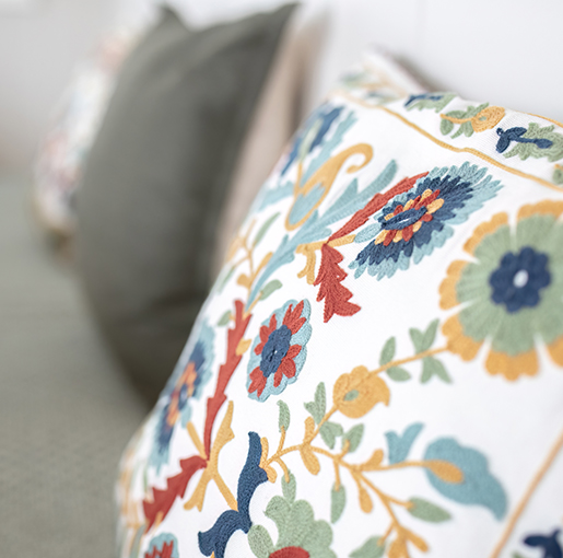 Close-up of an embroidered cushion with elegant textured detailing.