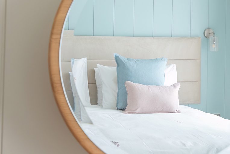 Mirror reflecting the beautifully appointed second bedroom in The Sandpiper.