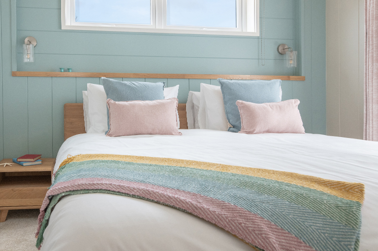 Beautifully styled master bedroom at The Sandpiper featuring calming colours and coastal design