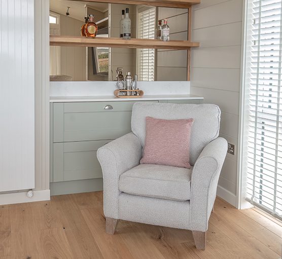 Armchair positioned in front of the built-in cocktail station.