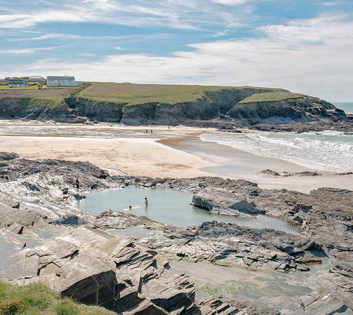 Scenic view of Treyarnon Bay with sandy beach and famous rock pool at low tide
